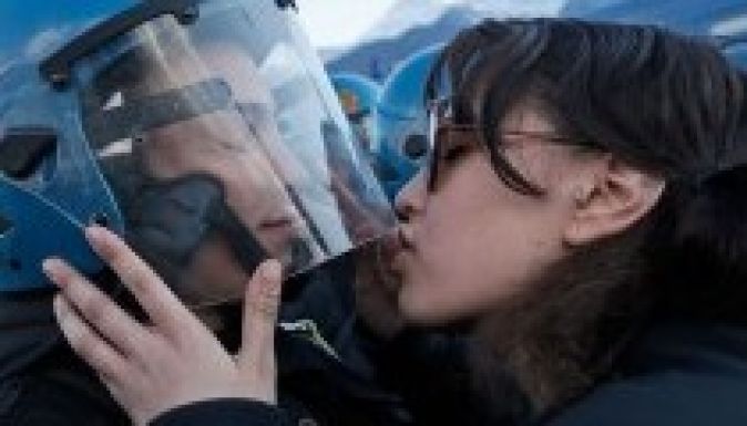 Szexuális zaklatással vádolják a rendőr sisakját csókoló lányt