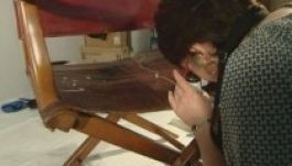 Összetört Napóleon széke egy kíváncsi múzeumi dolgozó alatt