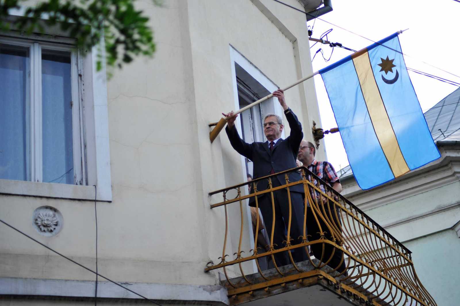 Tőkés László kitűzi a székely zászlót nagyváradi irodája erkélyén | Fotó: a politikus sajtóirodája