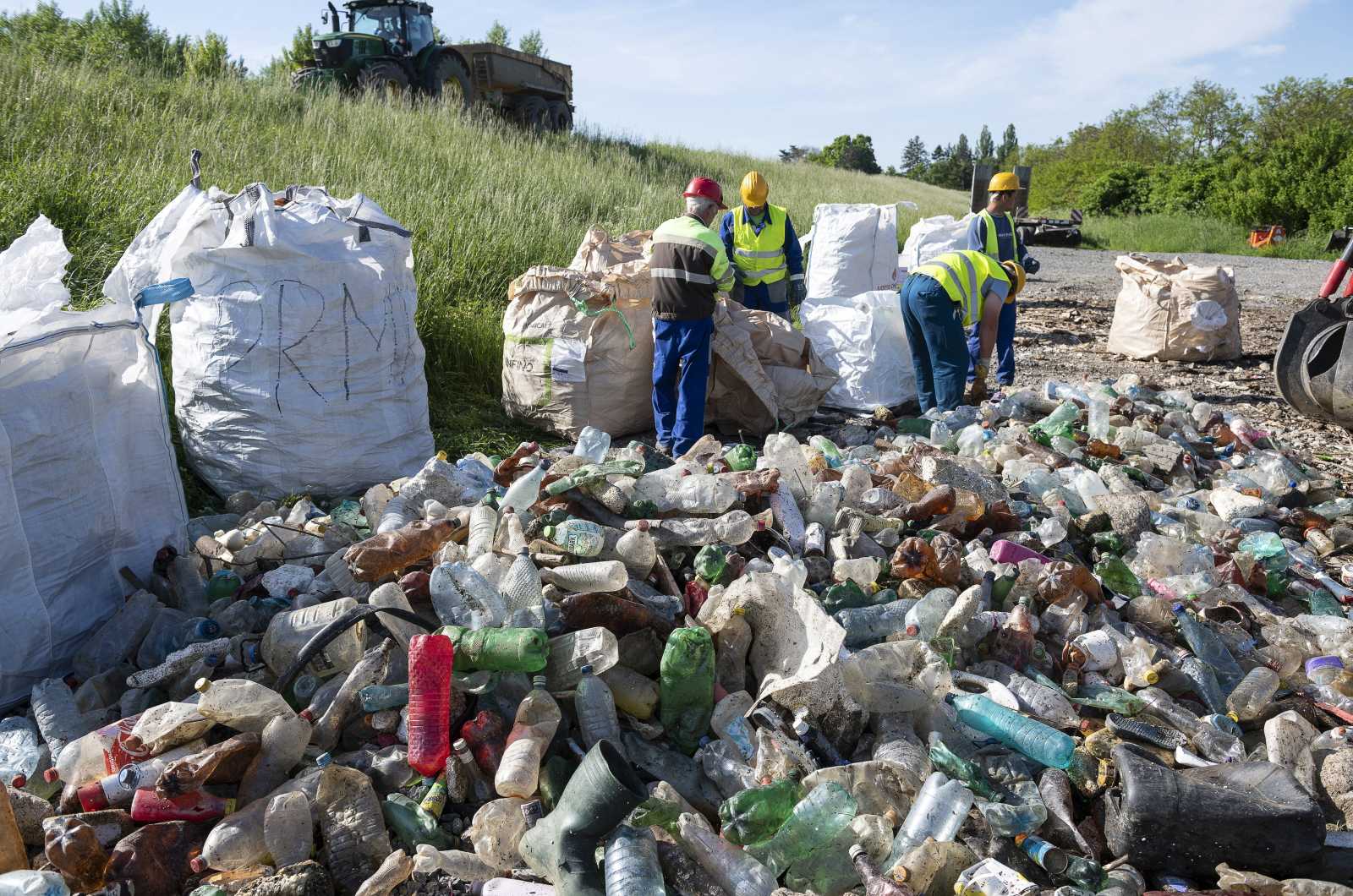 A Felső-Tisza-Vidéki Vízügyi Igazgatóság munkatársai szelektálják a munkagépekkel kiszedett, a romániai vízgyűjtőről a Szamoson árhullámmal érkezett hulladékot az Olcsvánál kialakított hulladékdepóban | Fotó: MTI/Balázs Attila