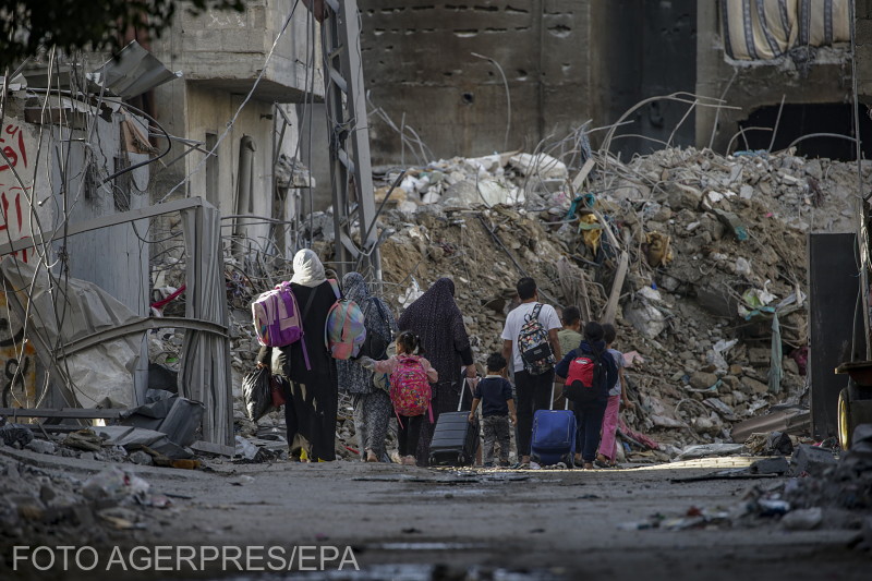 Menekülő lakosok haladnak el egy lerombolt épület mellett a Gázai övezet északi részén az izraeli légicsapásokat követően.