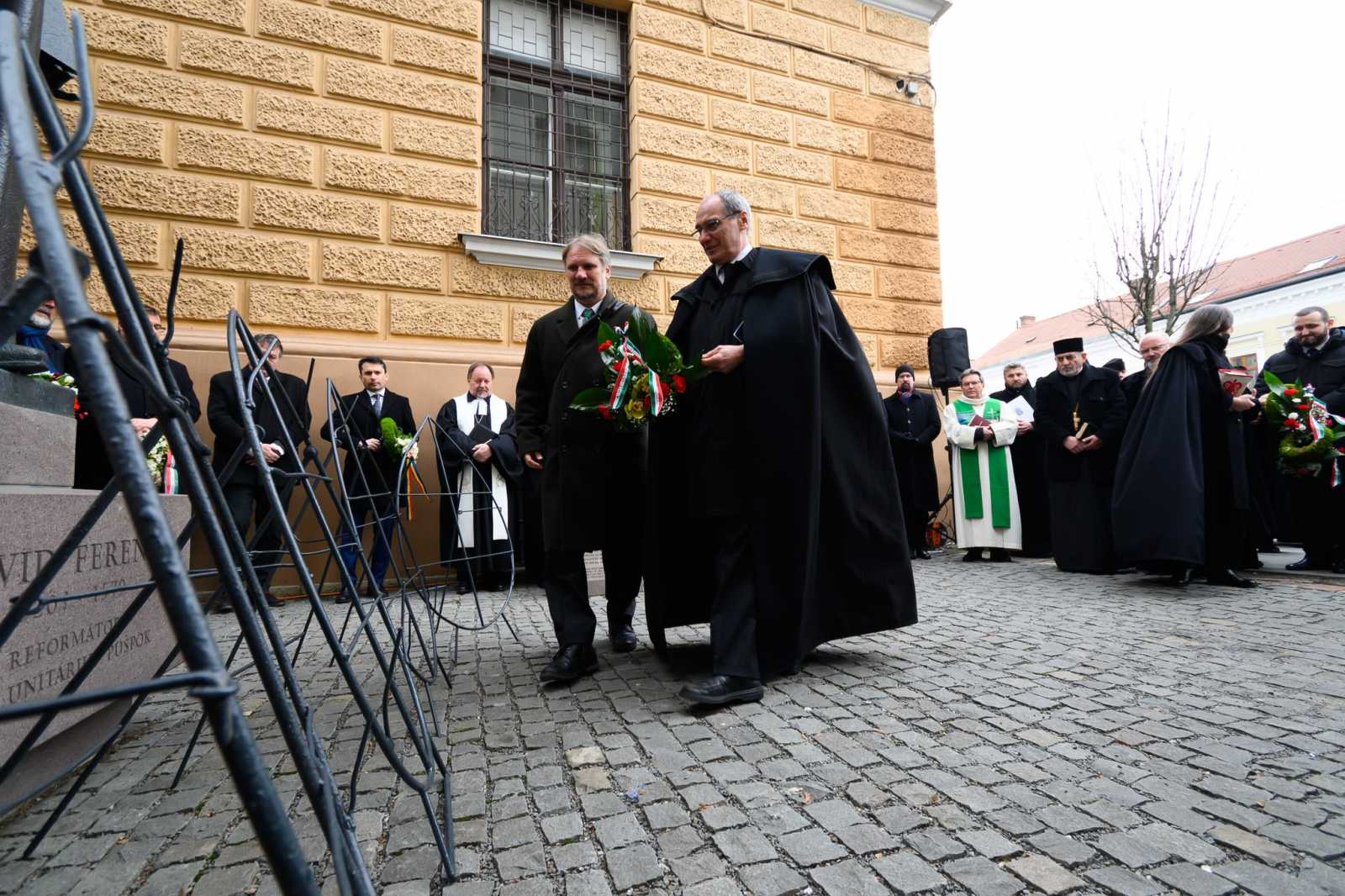 Dávid Ferenc szobrához helyez el koszorút Kovács István püspök és Farkas Emőd főgondnok a 2024-es megemlékezésen.