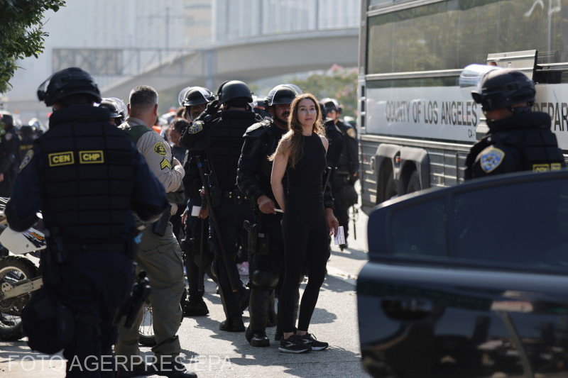 Egy tüntetőt épp letartóztatnak és buszra tesznek Los Angelesben. | Fotó: Agerpres
