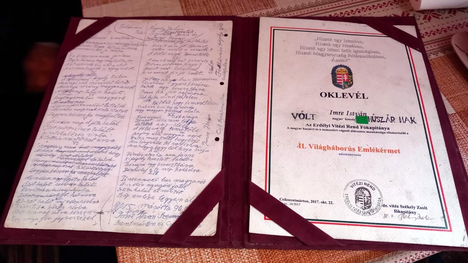 Díszoklevél, mellette pedig a fogolytáborról szóló vers szövege