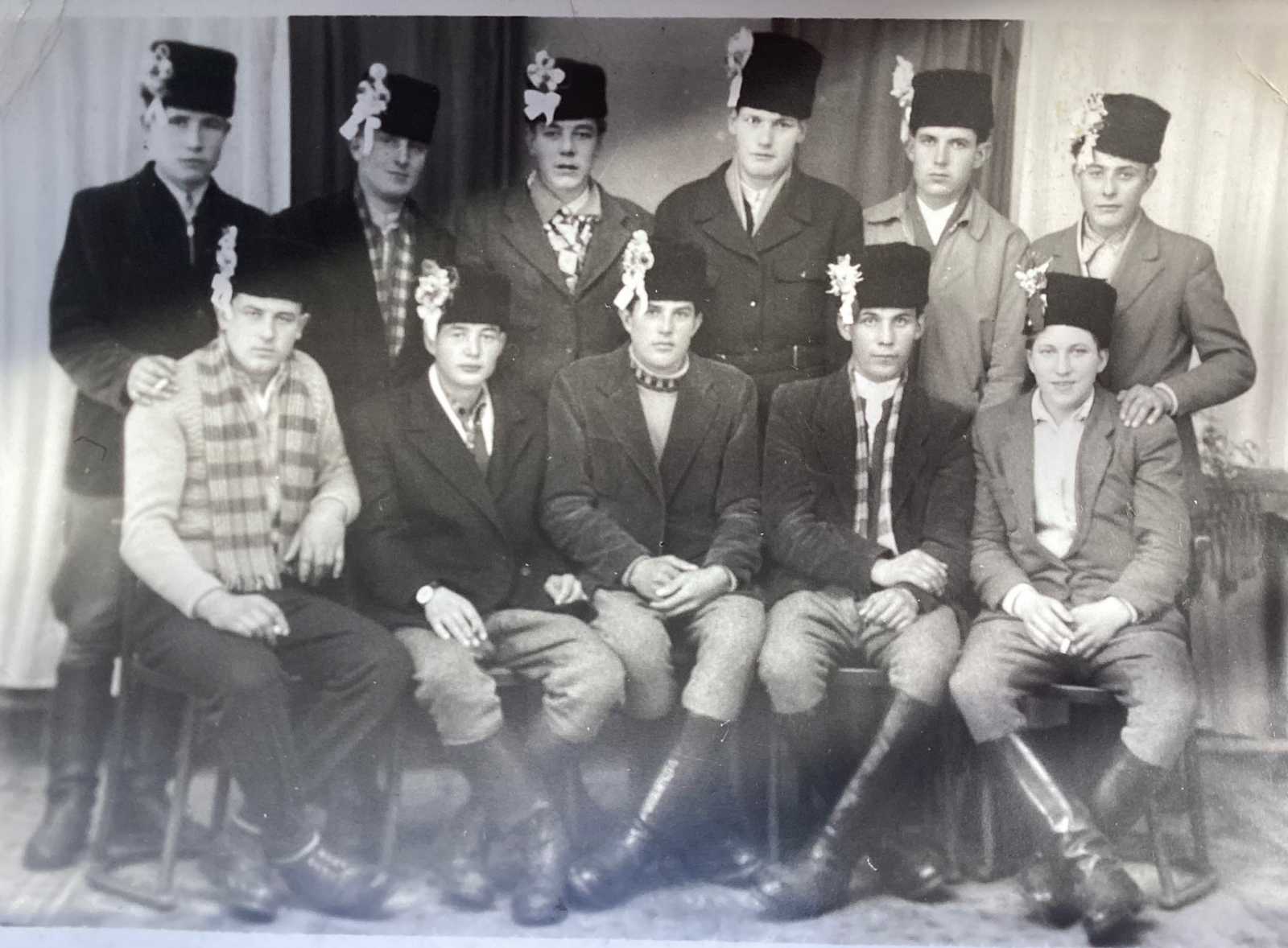 A régi magyar hagyomány szerint a regruták, mielőtt bevonultak katonának, egy jellegzetes szalaggal / tollal vagy bokrétával díszített kalapot viseltek ( a katonai szolgálatot megelőző 4-12 hónapig ) Fotón: álló sor, jobbról a második : M. Miklós. Gyergyóújfalu, 1961. | Fotók forrása: Gyergyói Digitális Archívum