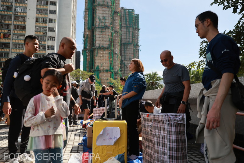 Önkéntesek osztanak segélycsomagokat a lakástűz helyszínén Hongkongban pénteken.