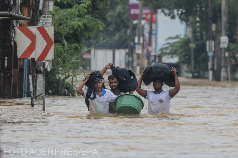 Árvízkárosultak gázolnak át egy elárasztott úton a heves esőzések alatt Colombo külvárosában, Srí Lanka, 2025. november 29-én. | Fotók: Agerpres
