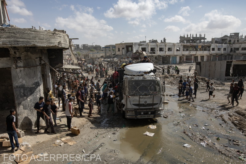 Palesztinok gyűlnek a segélyszállítmányokat szállító teherautók köré, amelyek 2025. október 11-én érkeztek Khan Yunisba, a Gázai övezet déli részén. | Fotó: Agerpres