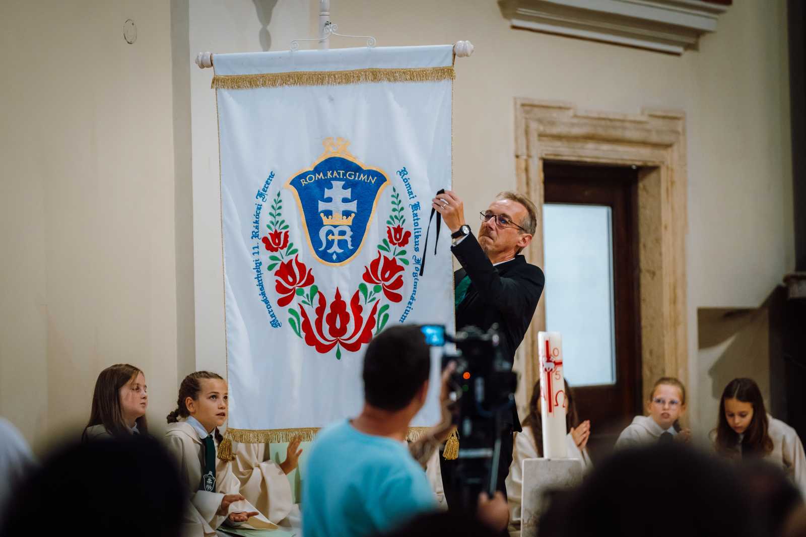 Tamási Zsolt a Rómaik Katolikus Líceum igazgatója leveszi a fekete szalagot az iskola zászlajáról. | Fotó: Gáspár Attila