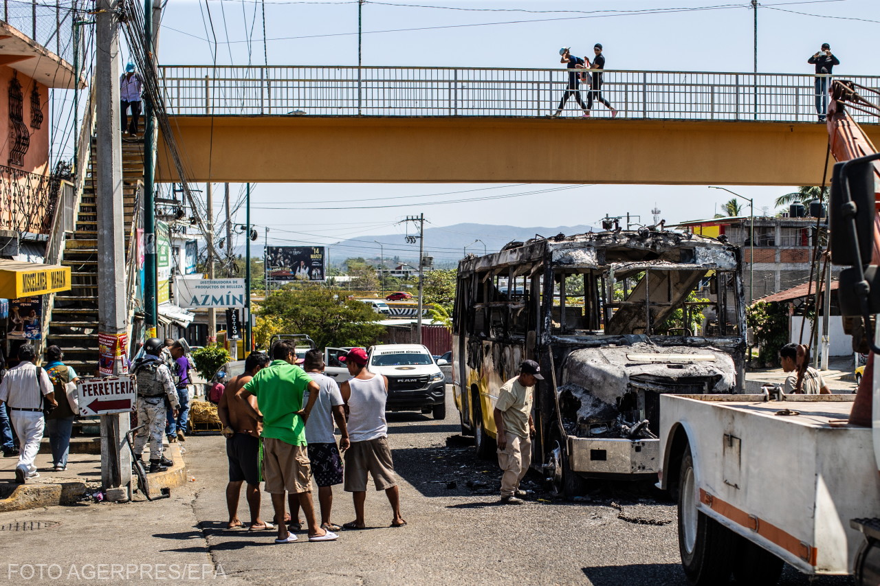 Feltehetően a szervezett bűnözők által felgyújtottak buszt szemlélnek a mexikói üdülővárosban, Acapulcóban. 