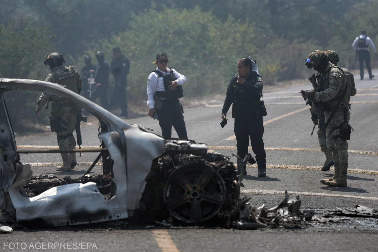 Rendőrtisztek és katonák helyszínelnek, miután egy járművet gyújtottak fel feltehetően a bűnszervezet tagjai.