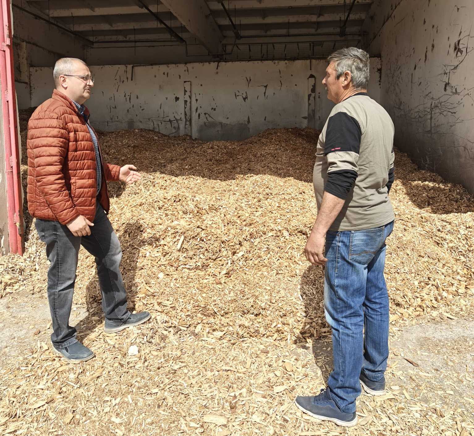 Szakács Tibor, az Urbana vezérigazgatója és munkatársa a biomassza-alapú hőtermeléshez használt faőrlemény mellett | Fotó: Urbana Rt.
