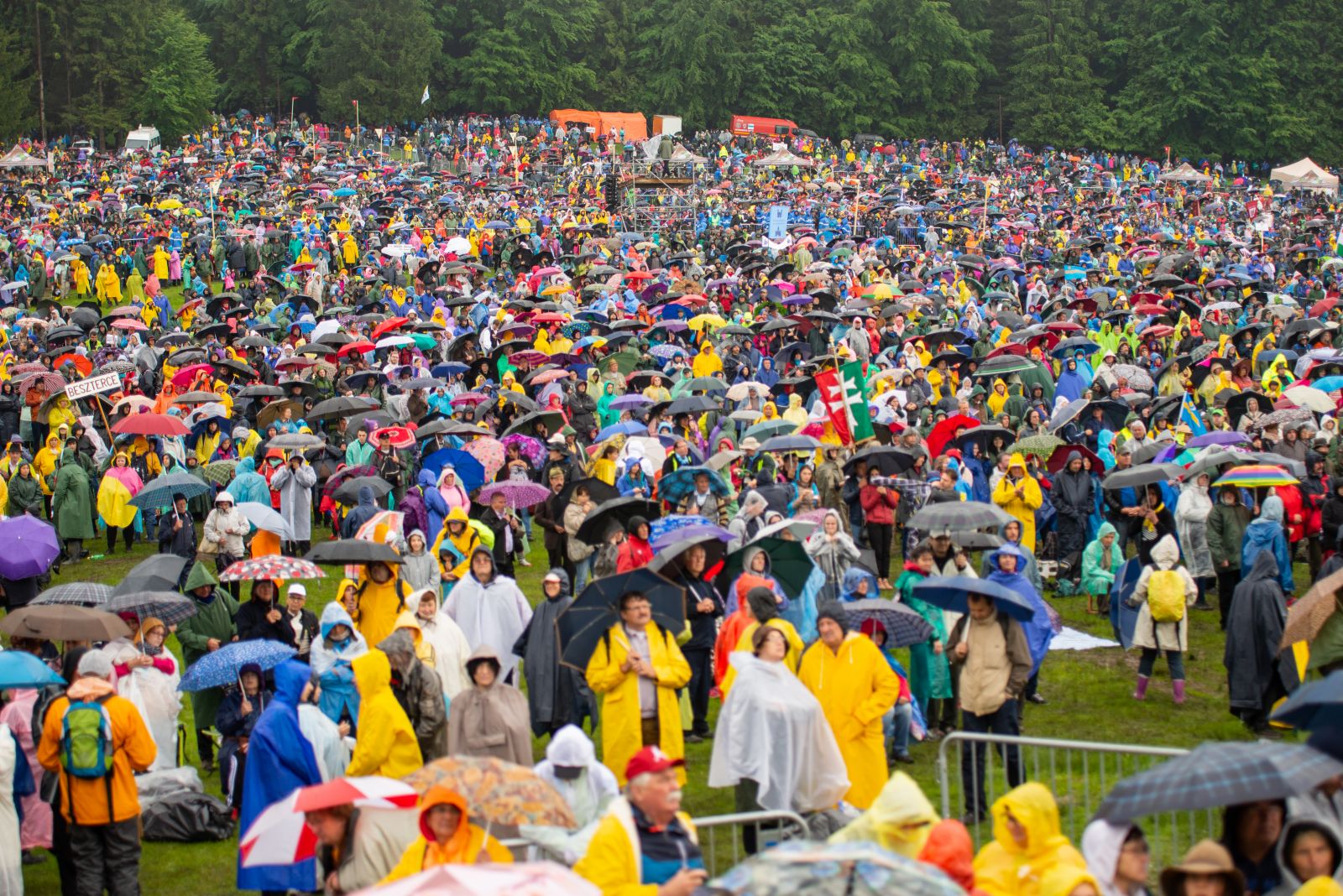 Esernyőerdő fedezékében, esőkabátokba burkolózva várták az emberek Ferenc pápa érkezését. Később elállt az eső és a szentmise végére kisütött a nap is.
