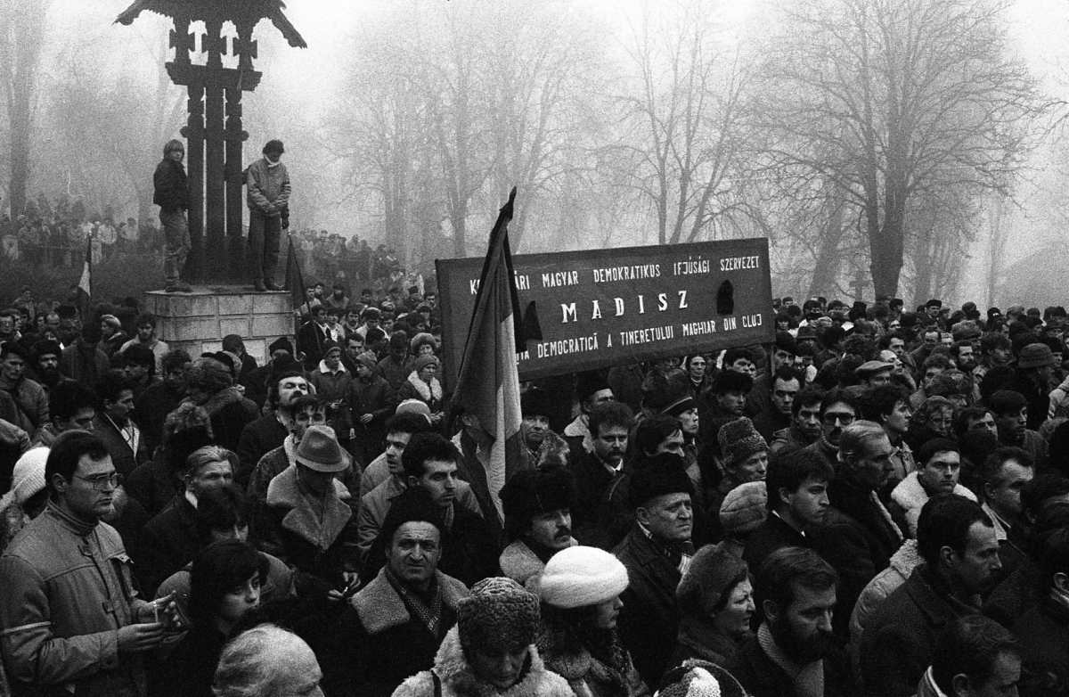 Feleki Károly fotója. Ceaușescu kivégzését követően temették el a forradalmárokat a hősök temetőjében, közös szertartás keretében. A tömegben transzparenseket is lehetett látni, az egyiken a MADISZ név is felbukkant.
