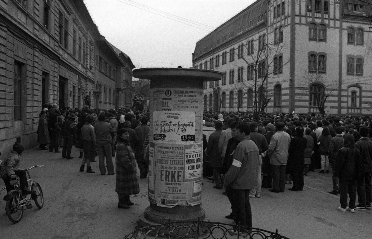Feleki Károly fotója. A márciusi programok plakátjai a hirdetőoszlopon és ünneplő tömeg a téren.