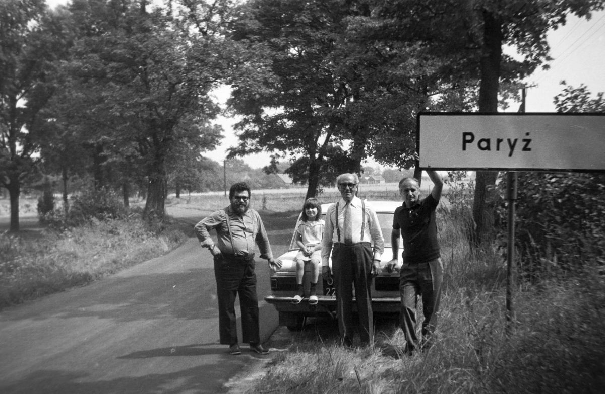 A lengyelországi „Párizs” határában egy korábbi lengyel évfolyamtársnál látogatóban a hetvenes években. Szűcs Loránd a helységnévtáblát tartja. Fotó: Fortepan / Szűcs Lóránd