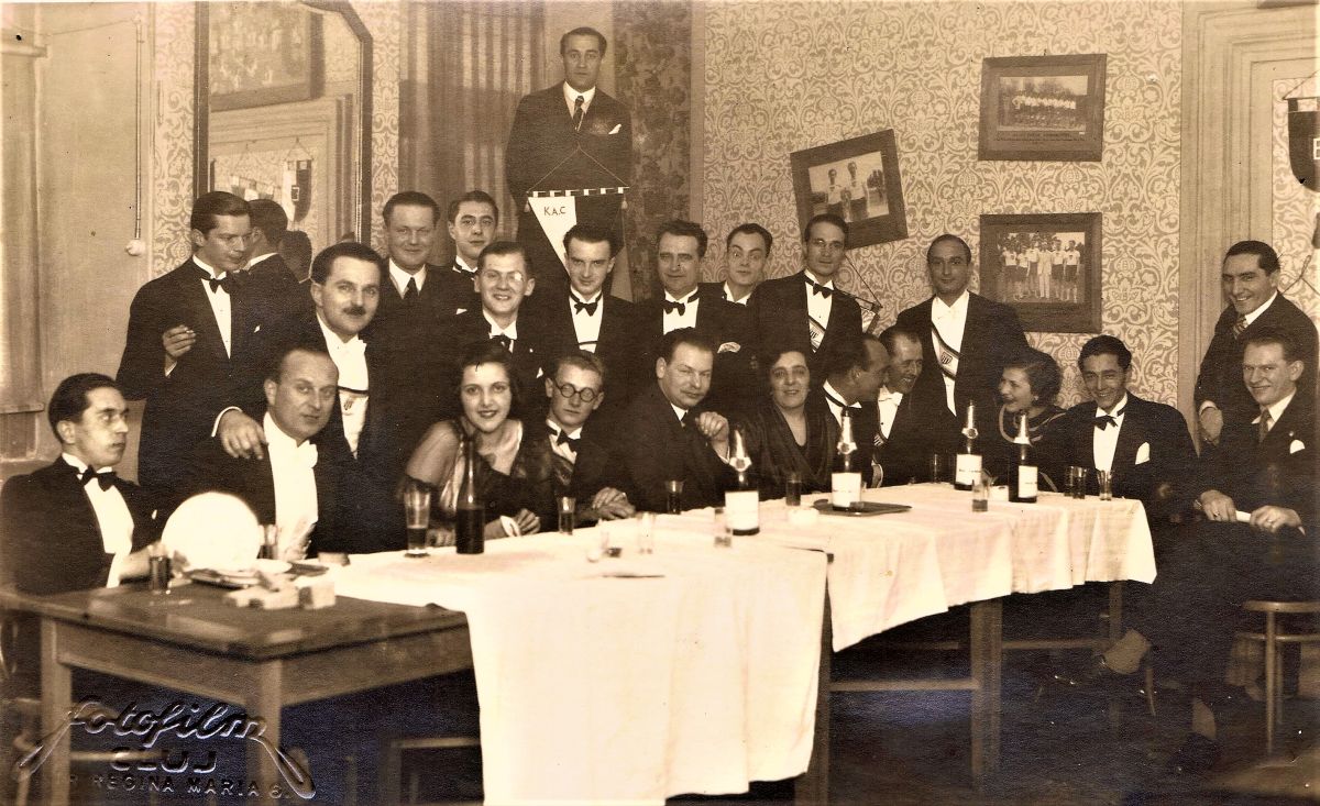 KAC-díszest 1933. február 5-én – az asztalfőn jobbra Szathmári Elek. Érdemes elveszni a részletekben, megfigyelni a korabeli öltözékeket, a vidám este tartozékait; borosüveget, üvegpoharat, cigarettát, a háttérben látható dekorációt, a falra akasztott klubzászlókat, a dicső pillanatokat megörökítő sportfotókat. (Fotó: Szathmári Elek hagyatéka)
