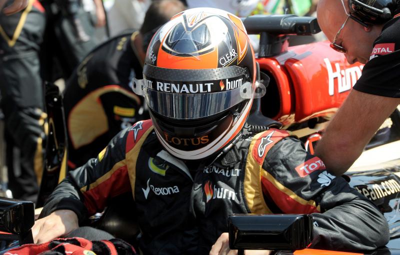 Kimi Räikkönen, a Lotus csapat finn versenyzője ül be versenyautójába a rajtrácson