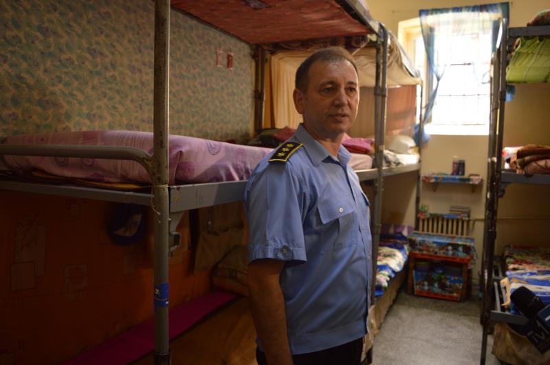 Vasile Pop börtönfelügyelő a 14 ágyas cellát mutatja