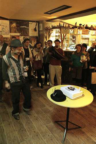Hajdu Szabolcs, a Békeidő rendezője a Kollokvium születésnapi tortáját és kabaláját (a három tollal díszített fekete kalapot) mustrálgatja