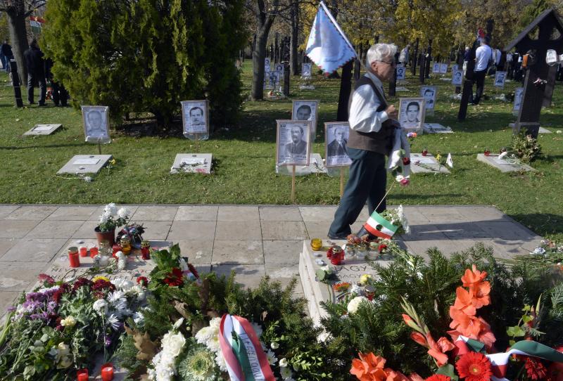 Egy megemlékező megy Nagy Imre mártír miniszterelnök sírja mellett megy a 301-es parcellában az 1956-os forradalom és szabadságharc 57. évfordulóján a Rákoskeresztúri Újköztemetőben 2013. október 23-án.
