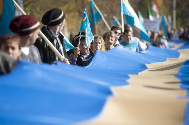A Székelyek nagy menetelésének résztvevői egy óriási székely zászlót visznek Kökösön, ahonnan Uzonba vonulnak.