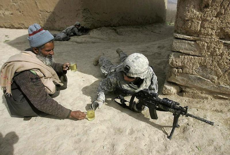 Afgán férfi teával kínál egy amerikai katonát.