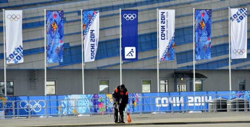 Egy munkás söpri a járdát a Szocsi Olimpiai Parkban.