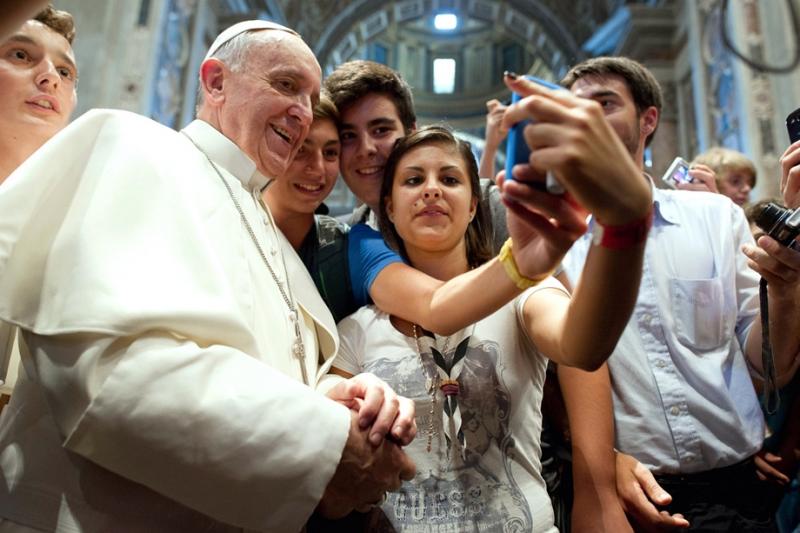 2013. augusztus 28. - Róma, Olaszország: Ferenc pápa szelfije fiatalokkal a belvárosi Saint Augustine templomban. A katolikus egyházfő szerint az internet segíthet a különböző embercsoportok közt lévő falak lebontásában azáltal, hogy lehetővé teszi a szab