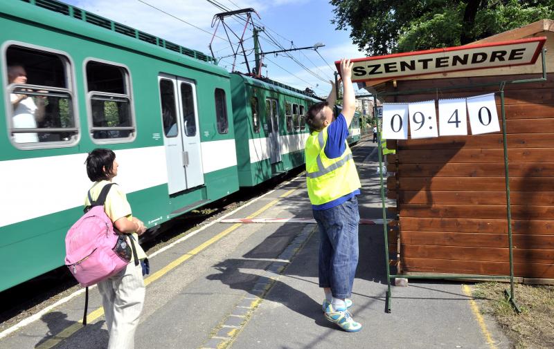 Az utasok tájékoztatására szolgáló, kézzel állítható kiljelzőt kezel egy munkatárs a HÉV Margit hídi ideiglenes végállomásán 2013. június 10-én.